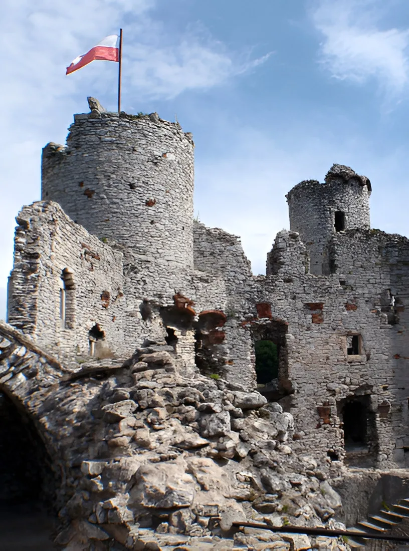 Ruined stone castle tower with a red and white flag