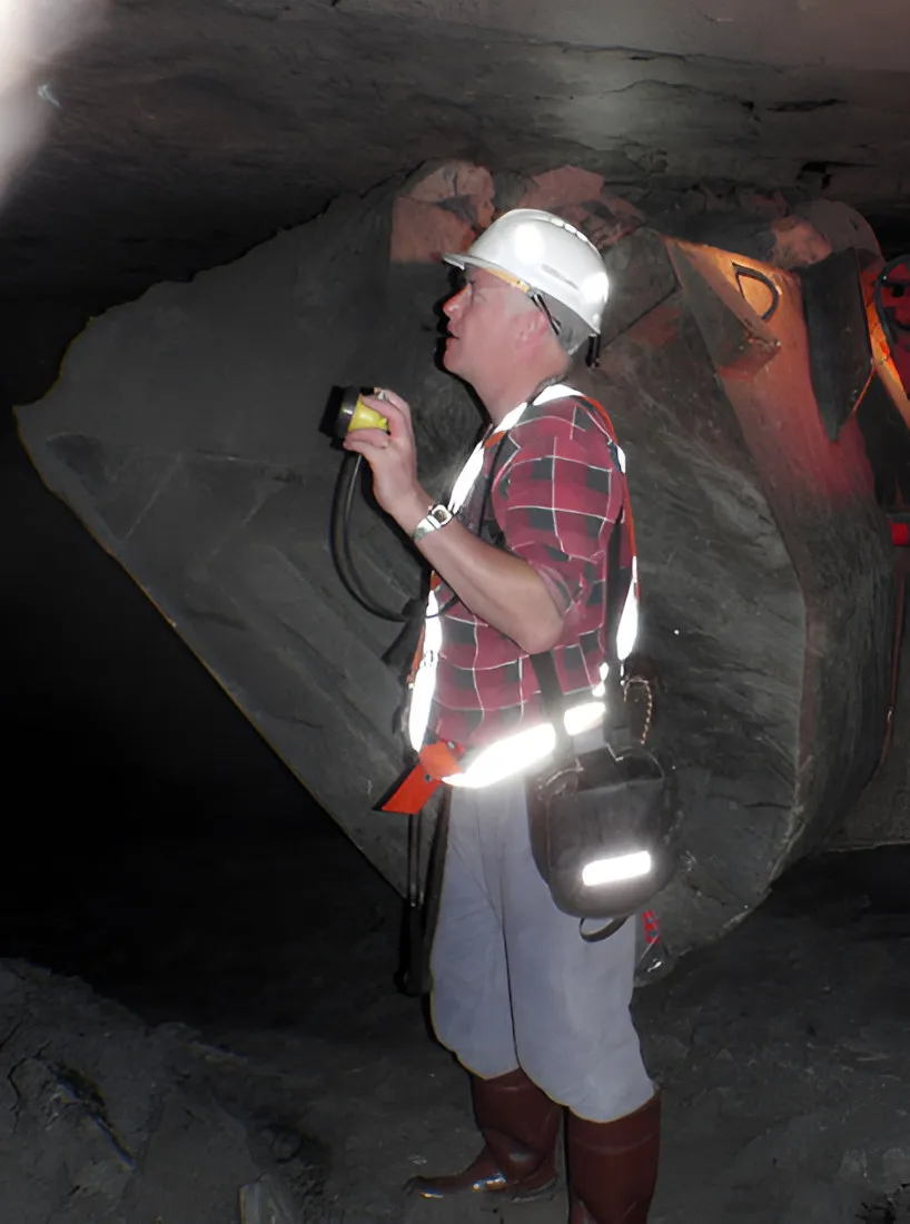 Man in a hard hat and reflective vest underground in a mine