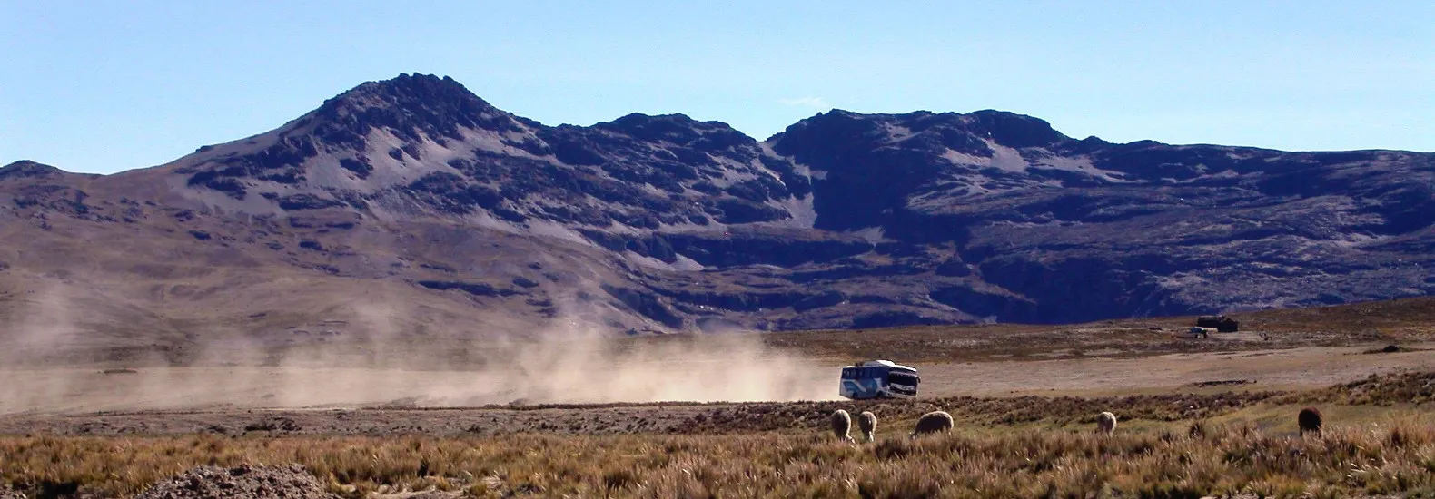 Vehicle raising dust on a track in the Peruvian Eastern Cordillera