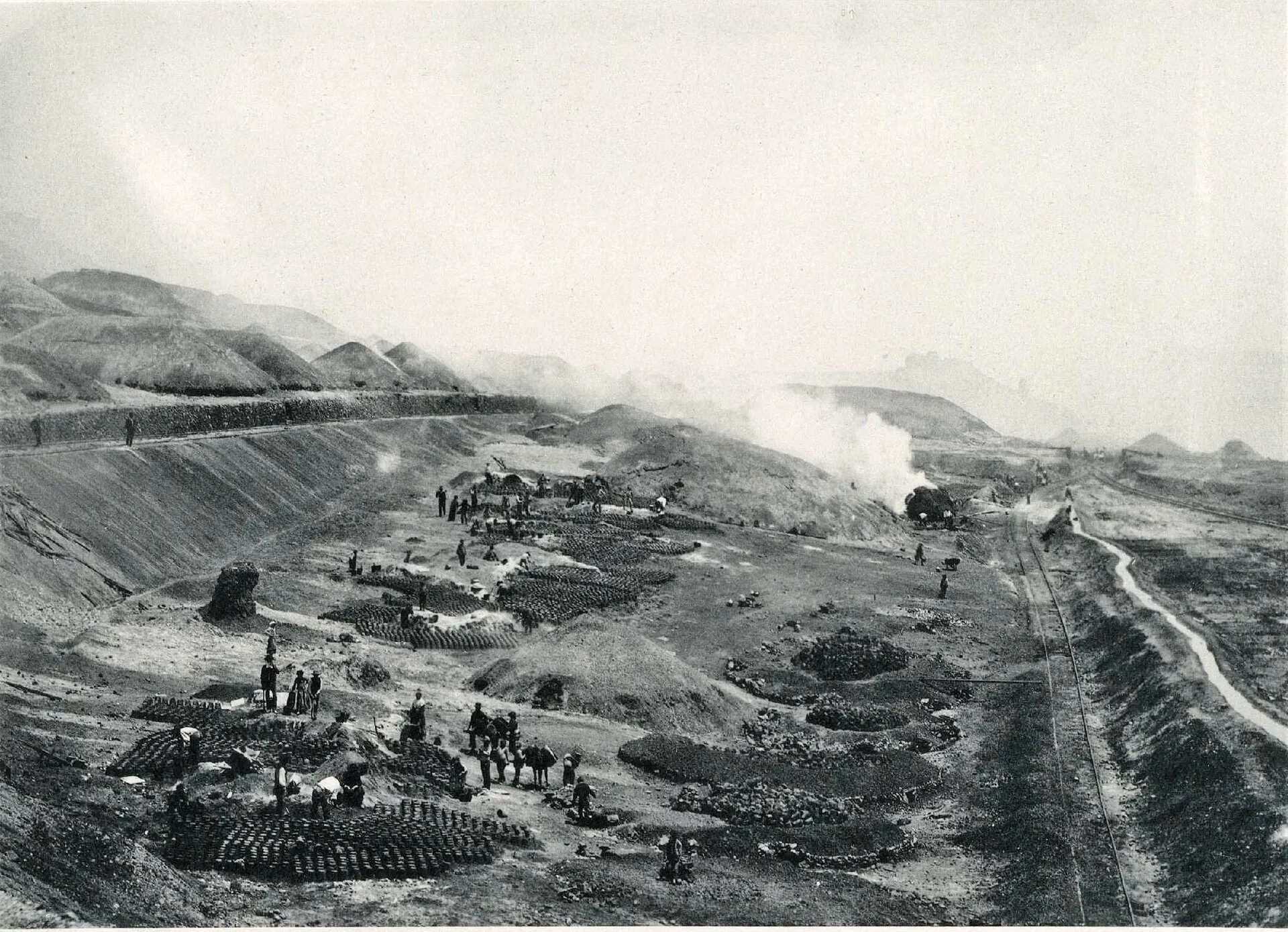 Black-and-white photograph of ore roasting beds and workers at the Riotinto mines, Huelva, 1892